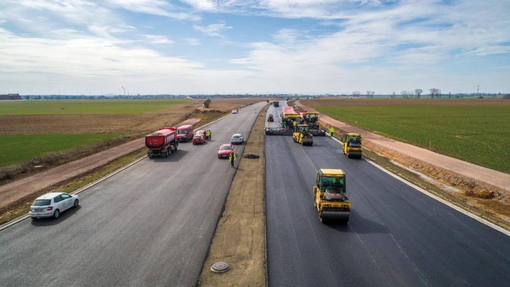 Pokládka asfaltových vrstev vozovky na dálnici D11