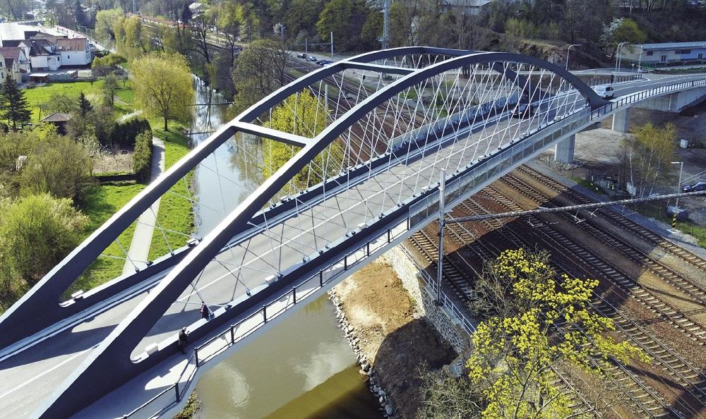 Ocelová nosná konstrukce mostu nad tratí a řekou.